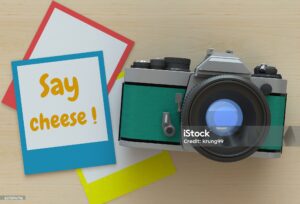 Green camera with polaroid photo that says "say cheese"