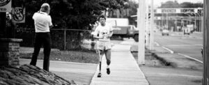Black and White photo on Terry Fox running on side walk.
